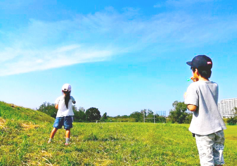 広い公園で子供達が寝転んでいる