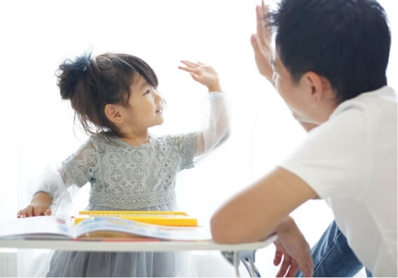子供と大人がハイタッチしている様子